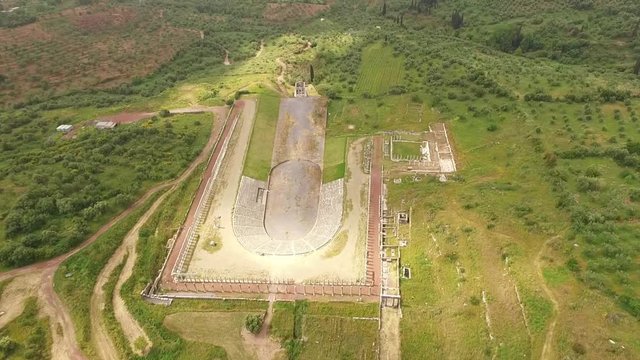 Aerial drone video of unique and well preserved archaeological site and citadel of Ancient Messene featuring massive stadium and theatre, Messinia, Peloponnese, Greece