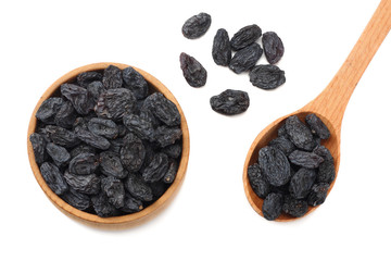 black raisins in wooden bowl isolated on white background. top view