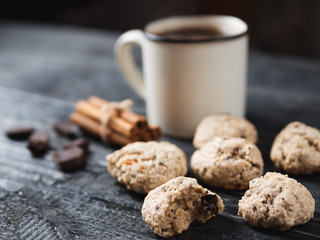 Homemade oatmeal cookies with dried fruits and nuts with coffee on wooden table