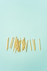 Wooden matches scattered on a turquoise pastel color background