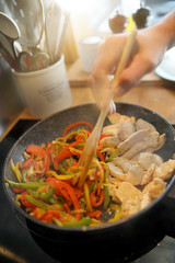 Closeup of frying pan with meat and vegetables being cooked