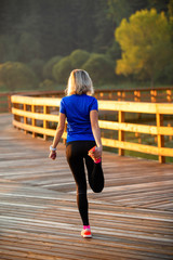 Image of young girl stretching in summer park