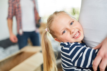 Glückliches Mädchen umarmt schwangere Mutter