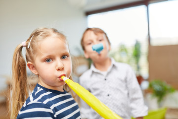 Kinder mit Tröte feiern auf einer Party