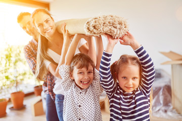 Kinder helfen Familie beim Teppich tragen
