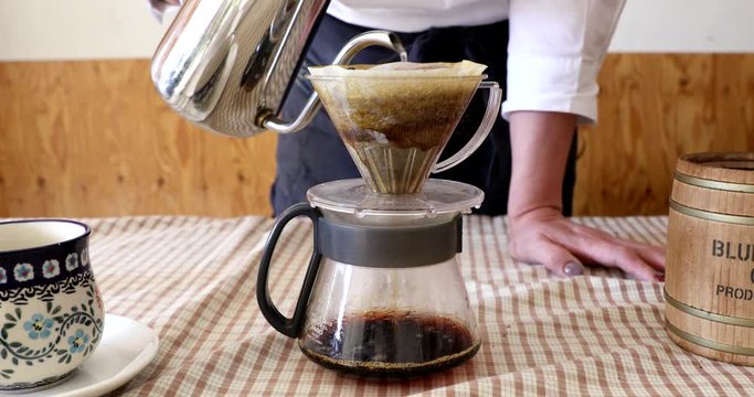 Barista pouring water on ground coffee in kono dripper : Hand Drip Coffee, Kono drip