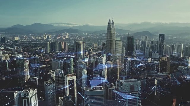Digital network connection lines of Kuala Lumpur. Financial district and business centers in smart urban city in Asia. Skyscraper and high-rise buildings at night.