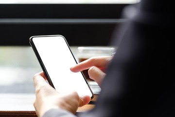 Close up Woman hand Using a Smart Phone at cafe coffee shop, Blank screen mobile phone for graphic display