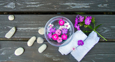 spa round sea pebbles and pink flowers on wooden background