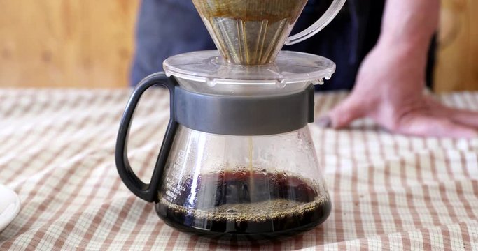 Barista pouring water on ground coffee in kono dripper : Hand Drip Coffee, Kono drip