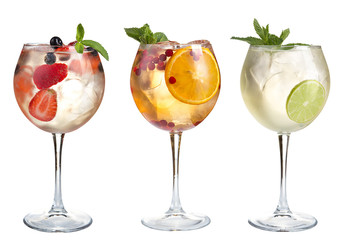 Cocktail with mint, fruits and berries on a white background. A set of three cocktails in glass goblets on a long stem.