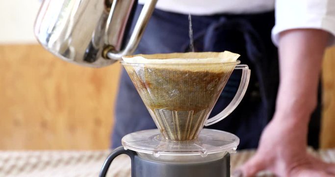 Barista pouring water on ground coffee in kono dripper : Hand Drip Coffee, Kono drip