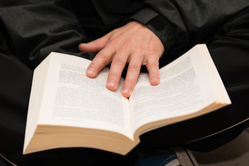 Naklejka premium Man hands holding a book with dog-ears.