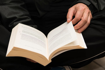 Fototapeta premium Man hands holding a book with dog-ears.