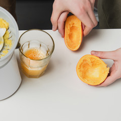 cropped view of couple with oranges preparing juice during breakfast