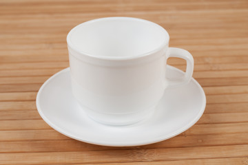 White cup mock-up inclined of wooden table