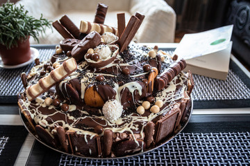 Beautiful homemade cake with chocolate, chocolate cookies and candies