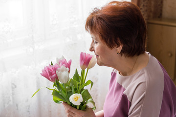 adult Russian woman with a bouquet of white and pink tulips, a woman with flowers