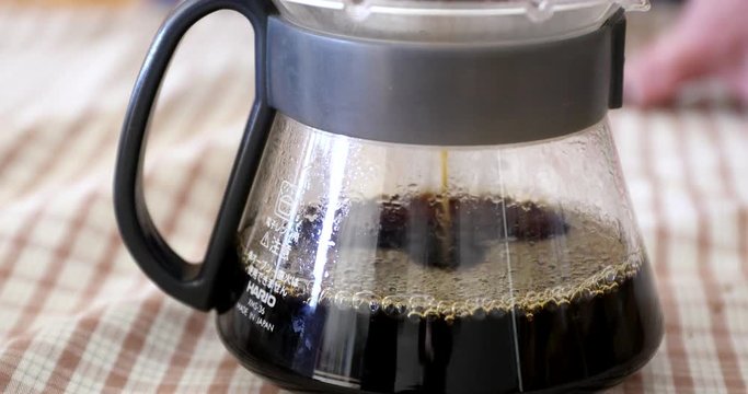 Barista pouring water on ground coffee in kono dripper : Hand Drip Coffee, Kono drip