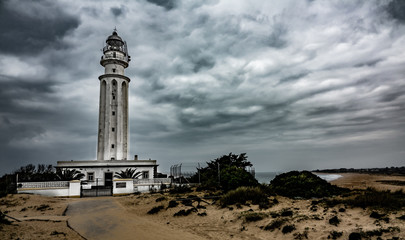 Trafalgar lighthouse with dramatic noisy sky in Cadiz