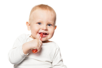 Baby teeth care. Smiling boy brushing his teeth with a toothbrush for infant. Isolated portrait