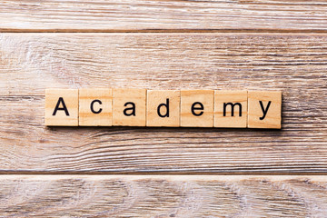 ACADEMY word written on wood block. ACADEMY text on wooden table for your desing, concept
