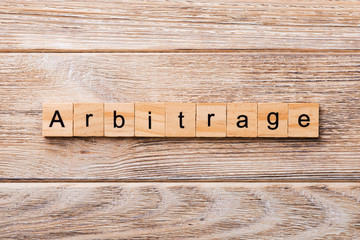 Arbitrage word written on wood block. Arbitrage text on wooden table for your desing, concept.