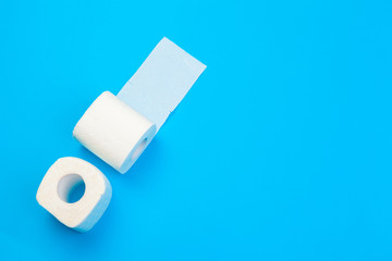Rolls of toilet paper on color background, top view