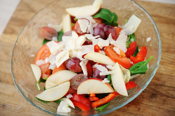 Multicomponent vegetable hearty salad in a bowl on a wooden board