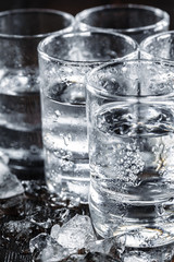 Vodka in shot glasses on rustic wood background