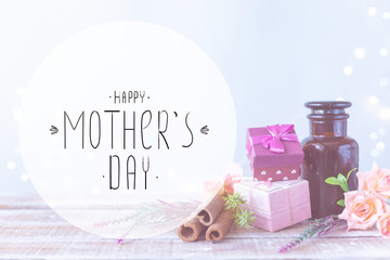 Boxes with gifts, a bouquet of flowers, cosmetic oil on a light blue background with the inscription Happy Mothers Day