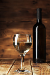 Wine bottles with glass, wooden background