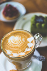 Cup of Latte on the table in coffee shop background