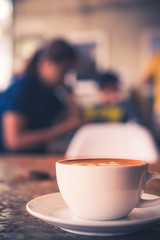 Cup of Latte on the table in coffee shop background