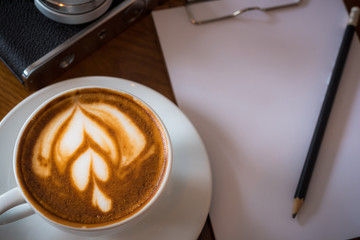 Cup of Latte on the table in coffee shop background