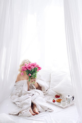 surprise at womans day for her. Breakfast on bed and pink tulips.