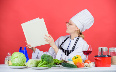 Culinary expert. Woman chef cooking healthy food. Girl read book top best culinary recipes. Culinary school concept. Female in hat and apron knows everything about culinary arts. Traditional cuisine