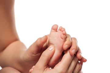 Mother massages her little baby's feet