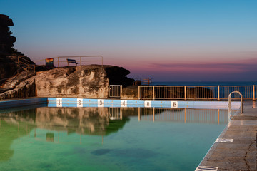 Empty Queenscliff rock pool with sunrise sky.