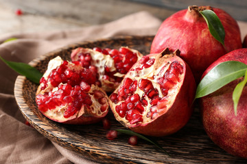 Plate with ripe pomegranates on table