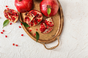 Metal tray with ripe pomegranates on white background