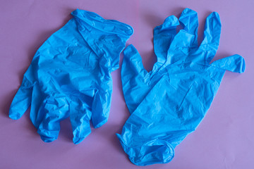 blue rubber gloves on pink background. overalls and uniforms. hand protection