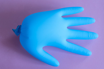blue rubber gloves on pink background. overalls and uniforms. hand protection