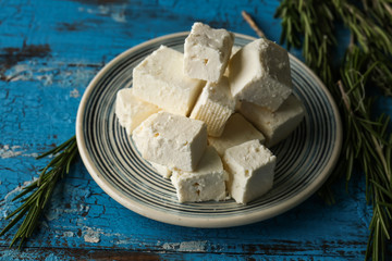 Plate with tasty feta cheese on table