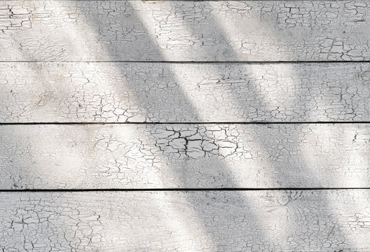 White wooden shabby weathered planks with sunlight, old light desk cracked paint wood board vintage texture, sun rays on rustic table pattern rough uneven grunge retro flaky structure, top view