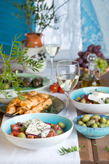 Fototapeta na wymiar traditional Greek lunch: salad with feta, souvlaki, olives and wine