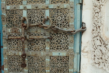 ancient medieva gate with a bolt and chain decorated with rich ornament