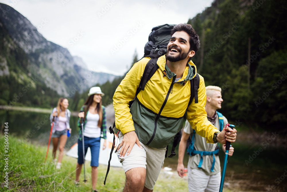 Wall mural group of young friends hiking in countryside. multiracial happy people travelling in nature