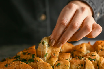 Woman eating tasty garlic bread, closeup