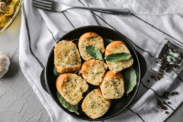 Pan with tasty garlic bread on table